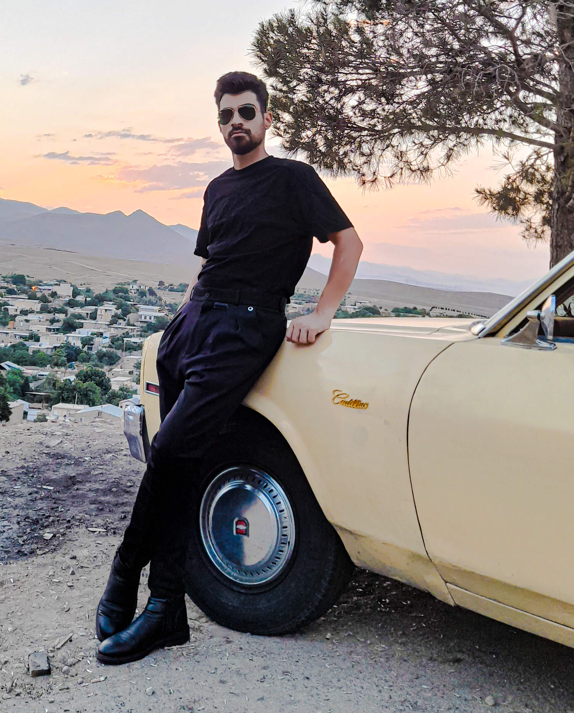 «مجتبی جاهد در کنار کادیلاک کلاسیک زرد در زمان غروب؛ ترکیب استایل مینیمال و خودروی خاطرهانگیز آمریکایی»